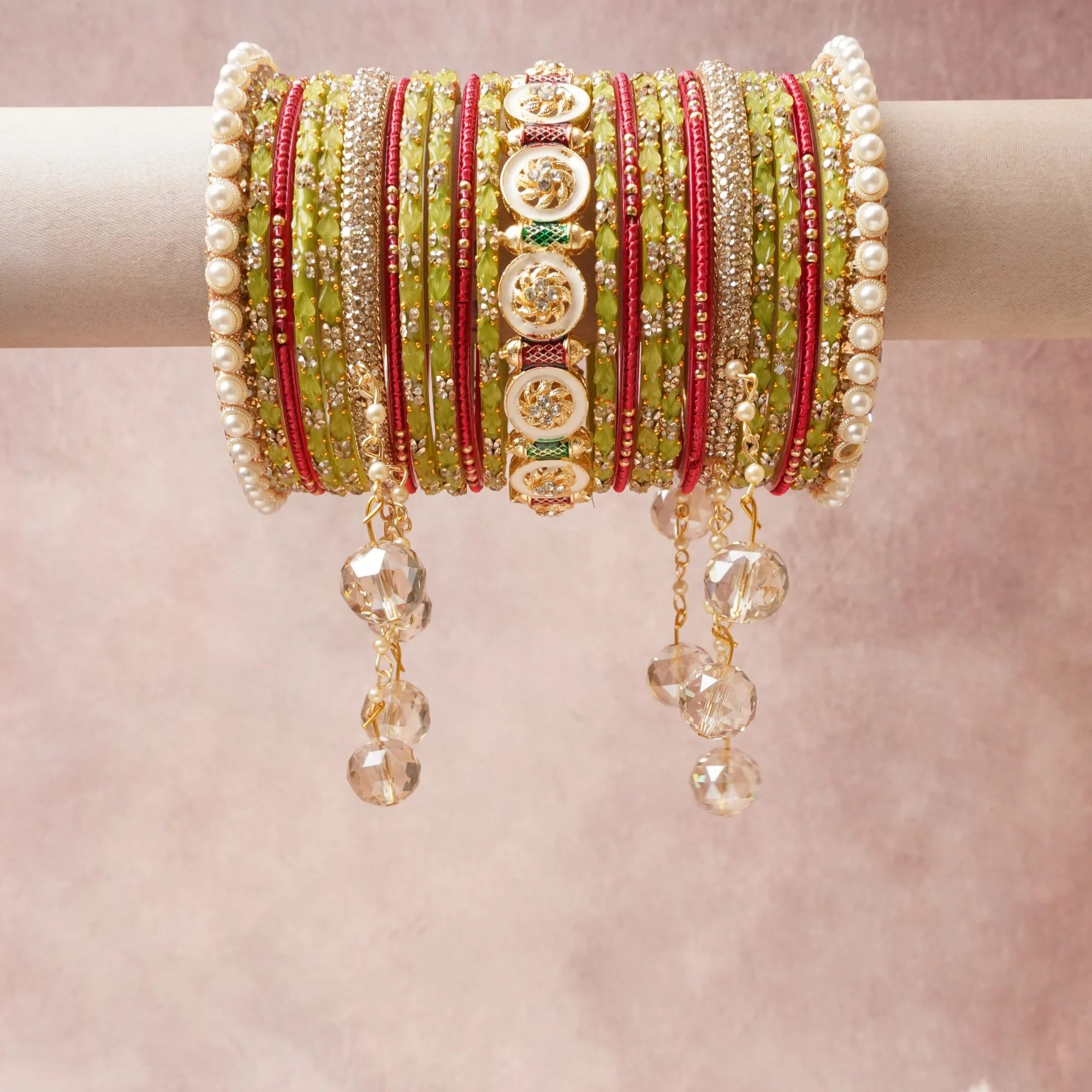 A commanding Verdant Green anchors this beautiful set, enriched with accents of Scarlet Red, Warm Gold, Cream Enamel, Lustrous Pearl, Brilliant White that add depth and dimension.

Featuring a striking composition of Glass Bangles, Silk Thread, Gold-toned Metal, Faux Pearls, Cubic Zirconia, Enamel, Faceted Glass Beads, this set carries intricate craftsmanship and strong presence. Grand in form, it is created for moments that deserve to be marked.
